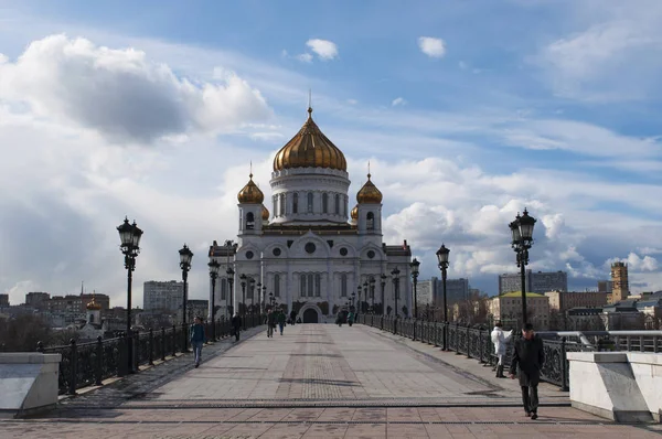 Moscou, Rússia: pessoas caminhando na Ponte do Patriarca com vista para a Catedral de Cristo Salvador, a igreja cristã ortodoxa mais alta do mundo — Fotografia de Stock