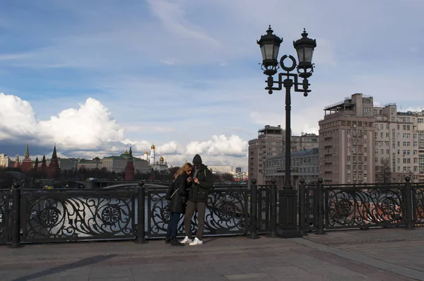 Moscou, Russie : un couple sur le pont du Patriarche sur la rivière Moskva avec l'horizon de Moscou avec le complexe fortifié du Kremlin sur le fond — Photo