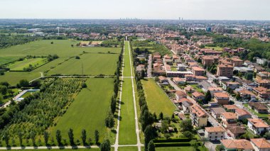 New Skyline of Milan seen from the Milanese hinterland, aerial view, tree lined avenue. Pedestrian cycle path.Varedo, Monza Brianza, Lombardy. Italy clipart