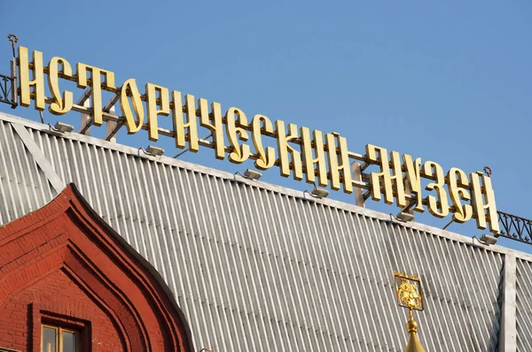 Moscou : le signe cyrillique d'or du Musée historique d'Etat, avec une énorme collection couvrant tout l'empire russe de l'âge de pierre logé dans un bâtiment rouge emblématique du 19ème siècle — Photo