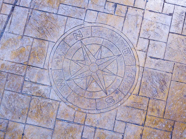 Rose of the winds and cardinal points inlaid in a pavement of a pier — Stock Photo, Image