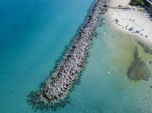 Letecký pohled na molo s kameny a skály na moři. Pier Pizzo Calabro, panoramatický pohled shora. Letní moře a turistiku na kalábrijském pobřeží jižní Itálie. Kalábrie, Itálie — Stock fotografie