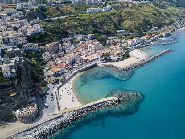 Vista aerea di una spiaggia e di un molo con canoe, barche e ombrelloni. Pizzo Calabro, Calabria, Italia . — Foto Stock