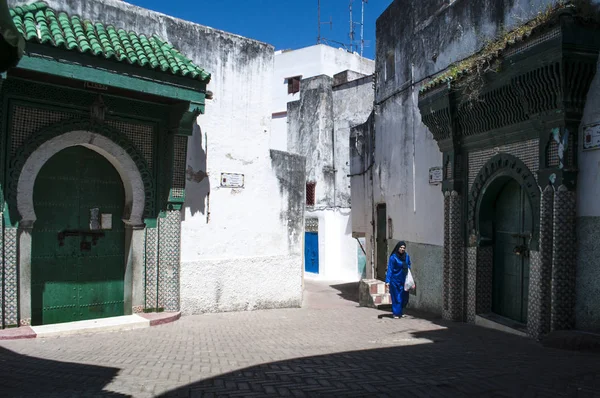 Marrocos, Norte de África: uma mulher muçulmana caminhando perto da mesquita na Place Aissawa, Praça Aissawa, na área de Medina, na cidade velha de Tânger, a cidade africana na costa do Magrebe — Fotografia de Stock