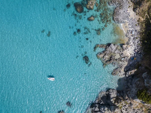 Flygfoto över en förtöjd båt flyter på ett öppet hav. Dykning avkoppling och sommarsemester. Italienska kuster, stränder och klippor — Stockfoto