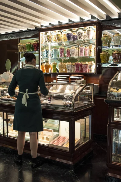 Italy: a waitress at the counter of the Pasticceria Marchesi, historic pastry shop in Milan since 1824, opened in 2016 inside the Prada boutique in the Galleria Vittorio Emanuele II — Stock Photo, Image