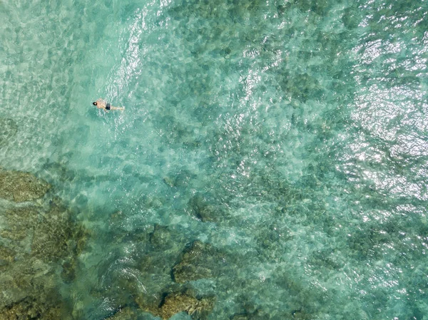 Luftaufnahme von Felsen auf dem Meer. Übersicht des Meeresbodens von oben gesehen, transparentes Wasser. Schwimmer, Badende, die auf dem Wasser schwimmen — Stockfoto