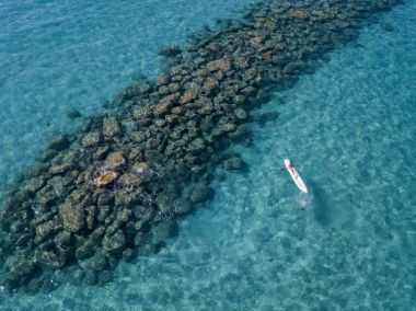 Şeffaf bir denizde yüzen su kanoyla hava görünümünü. Yıkananlara denizde. Zambrone, Calabria, İtalya. Dalış dinlenme ve yaz tatil. İtalyan kıyıları, plajları ve kayalar