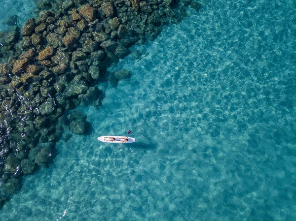 Luftaufnahme eines Kanus im Wasser, das auf einem transparenten Meer schwimmt. Badende auf See. Zambrone, Kalabrien, Italien. Taucherentspannung und Sommerferien. Italienische Küsten, Strände und Felsen — Stockfoto