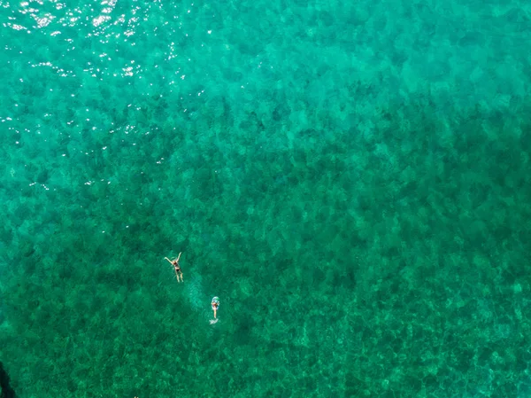 Luftaufnahme von Felsen auf dem Meer. Übersicht des Meeresbodens von oben gesehen, transparentes Wasser. Schwimmer, Badende, die auf dem Wasser schwimmen — Stockfoto