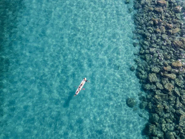 Luftaufnahme eines Kanus im Wasser, das auf einem transparenten Meer schwimmt. Badende auf See. Zambrone, Kalabrien, Italien. Taucherentspannung und Sommerferien. Italienische Küsten, Strände und Felsen — Stockfoto