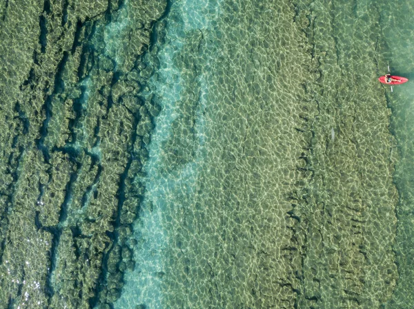Luchtfoto van een kano in het water drijvend op een transparante zee. Zwemmers op zee. Zambrone, Calabrië, Italië. Duiken ontspanning en zomervakanties. Italiaanse kusten, stranden en rotsen — Stockfoto
