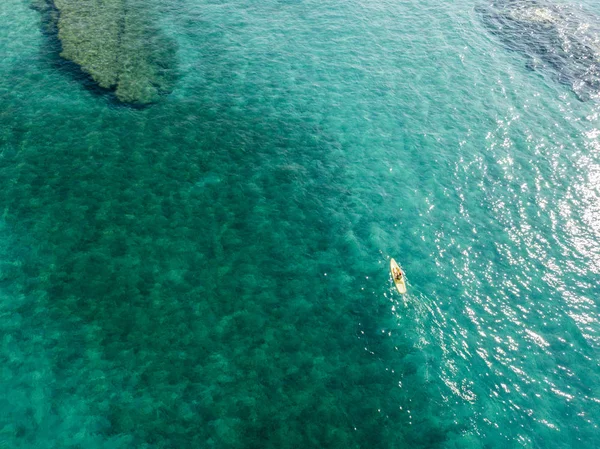 Luftaufnahme eines Kanus im Wasser, das auf einem transparenten Meer schwimmt. Badende auf See. Zambrone, Kalabrien, Italien. Taucherentspannung und Sommerferien. Italienische Küsten, Strände und Felsen — Stockfoto