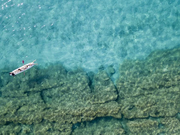 Luftaufnahme eines Kanus im Wasser, das auf einem transparenten Meer schwimmt. Badende auf See. Zambrone, Kalabrien, Italien. Taucherentspannung und Sommerferien. Italienische Küsten, Strände und Felsen — Stockfoto