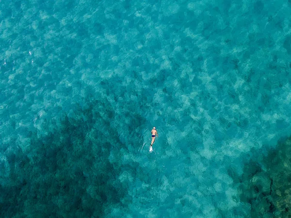 Luftaufnahme von Felsen auf dem Meer. Übersicht des Meeresbodens von oben gesehen, transparentes Wasser. Schwimmer, Badende, die auf dem Wasser schwimmen — Stockfoto