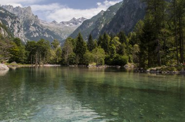 İtalya: Mello Valley, Val di Mello, granit dağlar ve Orman ağaçları ile çevrili bir Yeşil Vadi dağ gölü görünümünü İtalyan Yosemite Vadisi'nden Doğa severler tarafından değiştirildi.