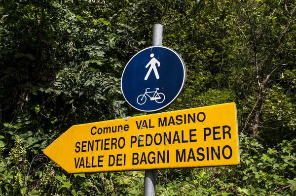 イタリア: ヴァッレ ・ ディ ・ バーニ Masino、花崗岩の山と森の木々 に囲まれた緑豊かな谷の歩道の看板変更自然愛好家によってイタリアのヨセミテ バレー — ストック写真