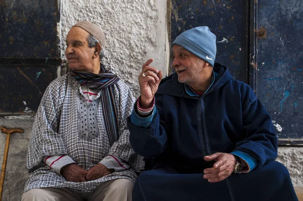 Morocco: old muslim men seated in the narrow alleys of Tangier, the moroccan city on the Maghreb coast with its unique blend of cultures, for centuries the Europe's gateway to Africa — Stock Photo, Image