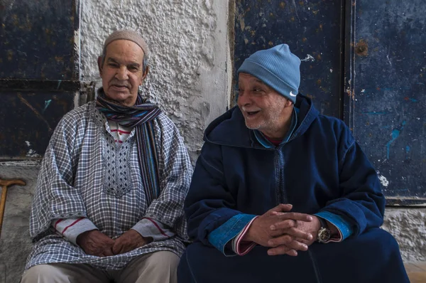 Marrocos: velhos muçulmanos sentados nas ruelas estreitas de Tânger, a cidade marroquina na costa do Magrebe com a sua mistura única de culturas, durante séculos a porta de entrada da Europa para a África — Fotografia de Stock
