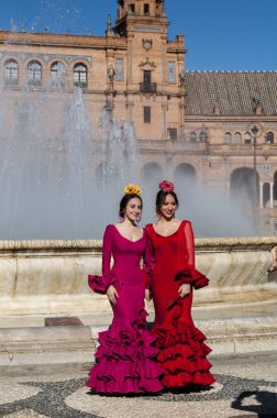 Spain: girls of Seville in typical dresses in Plaza de Espana, the most famous square of the city, ready for the Seville Fair (Feria de abril) which begins 2 weeks after Easter Holy Week clipart