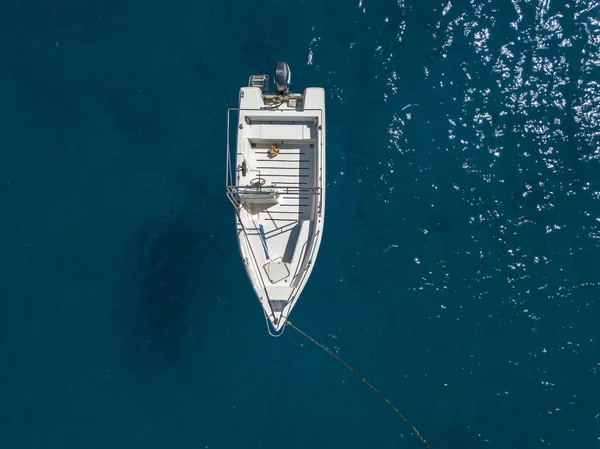 Luftaufnahme eines festgemachten Bootes, das auf einem transparenten Meer schwimmt — Stockfoto