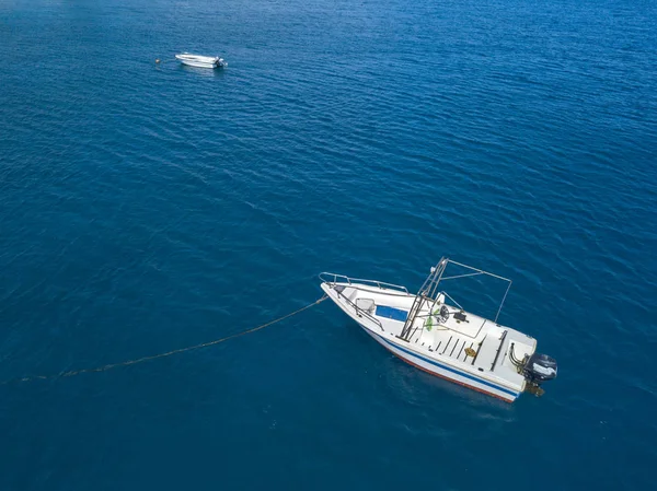 Şeffaf bir denizde yüzen bir demirli teknenin havadan görünümü — Stok fotoğraf