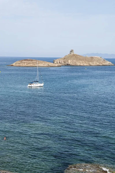 Korsika: Segelboot im Mittelmeer auf dem Cap Corse mit Blick auf das Naturschutzgebiet les iles finocchiarola, die drei kleinen Inseln, die terra, mezzana und finocchiarola genannt werden — Stockfoto