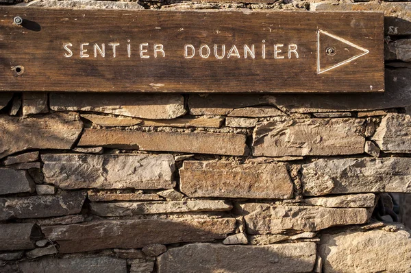Korsyka: kamienne ściany i drewniane znak Sentier des Douaniers (Custom oficerów trasy), słynny 19 km, długie wybrzeża ścieżki na Cap Corse, używany przez funkcjonariuszy celnych w przeszłości — Zdjęcie stockowe