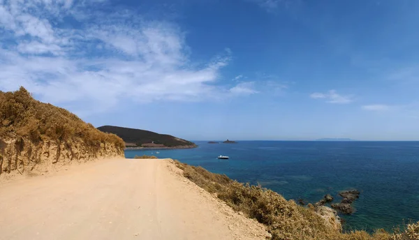 Corsica: the dirt road to Plage de Tamarone, Tamarone beach, one of the most famous and wild beaches of the Cap Corse, a long stretch of sand and rocky coves surrounded by the Mediterranean maquis — Stock Photo, Image