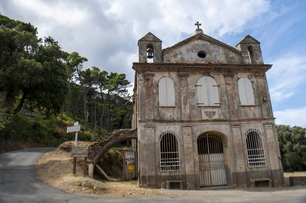 Córsega: a Capela Sainte Lucie, Capela Santa Lúcia, uma pequena igreja católica no coração da Cap Corse, a península norte da ilha francesa, vista da estrada sinuosa — Fotografia de Stock