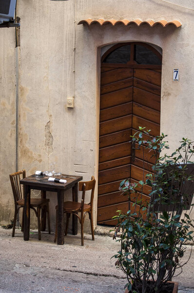 Corsica, 05/09/2017: outdoor table of a restaurant in the alleys of the old town of Bonifacio, the city at the southern tip of the island built on the site of a citadel dating from the 9th century