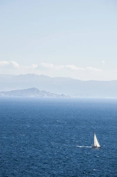 Corsica: a sailboat sailing in the Strait of Bonifacio, the stretch of sea between Corsica and Sardinia which divides the Tyrrhenian Sea from the western Mediterranean Sea — Stock Photo, Image