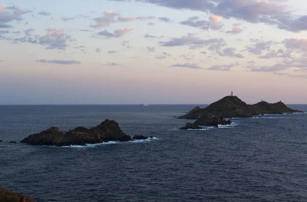 Korsika: en rosa solnedgång på den Iles Sanguinaires (blodiga öarna), berömda fyra mörk röd porfyr öar, en liten skärgård i golfen Ajaccio med en fyr som dating 1844 — Stockfoto