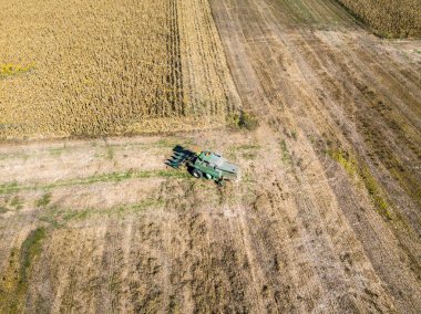 Hasat malzeme çekme tohumdan alanları, alanın cornhusker ürün toplama ile birleştirin hasat ile havadan görünümü birleştirmek