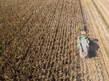 Hasat malzeme çekme tohumdan alanları, alanın cornhusker ürün toplama ile birleştirin hasat ile havadan görünümü birleştirmek