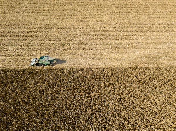 Combineren van harvester plukken zaad uit velden, luchtfoto van een gebied met een combine harvester met cornhusker voor het verzamelen van het gewas — Stockfoto