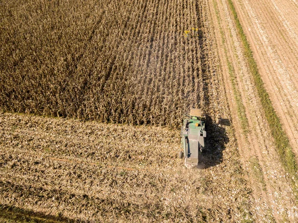 Combine colheitadeira colhendo sementes de campos, vista aérea de um campo com uma colheitadeira com cornhusker recolhendo a cultura — Fotografia de Stock