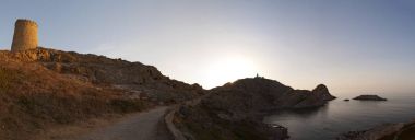 Korsika: Akdeniz ve nefes kesen bir gün batımı Ceneviz Kulesi ve Ile de la Pietra (taş Adası), kayalık promontory Ile-Rousse (Red Island), Upper Corsica bir şehir üstünde Pietra deniz feneri