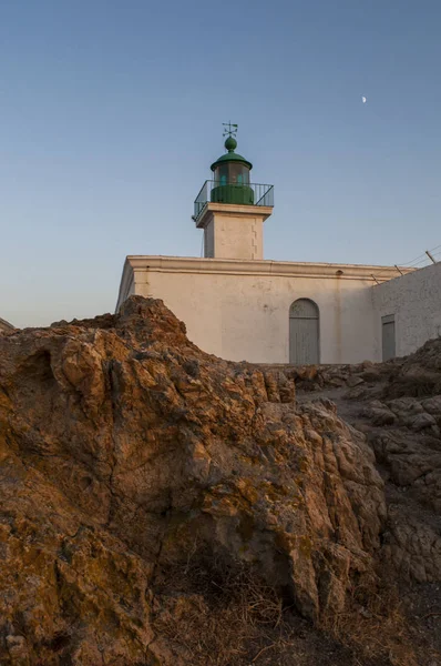 コルシカ島: ピエトラ灯台に沈む夕日は、Ile de la Pietra (石島)、イルルッス (赤島)、上部のコルシカ島の都市の岩の岬の上に 1857 年に発足 — ストック写真