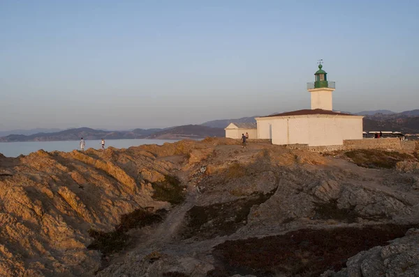 Korsika: Akdeniz ve Pietra Ile de la Pietra (taş Adası), Ile-Rousse (Red Island), Upper Corsica kenti kayalık promontory üst 1857 yılında açıldı deniz feneri üzerinde nefes kesen bir gün batımı — Stok fotoğraf
