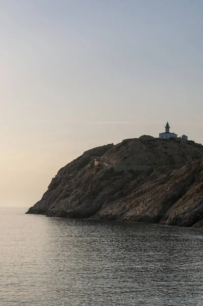 Córcega: el mar Mediterráneo y una impresionante puesta de sol en el faro de Pietra, inaugurado en 1857 en la cima de la Ile de la Pietra (Isla de Piedra), el promontorio rocoso de Ile-Rousse (Isla Roja), ciudad de la Alta Córcega — Foto de Stock