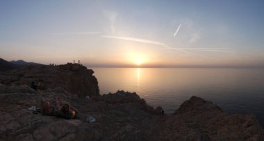 Corsica: Akdeniz denizde Ile de la Pietra (taş Adası), kayalık promontory Ile-Rousse (Red Island), Upper Corsica bir şehir tepesinden batımını insanlar