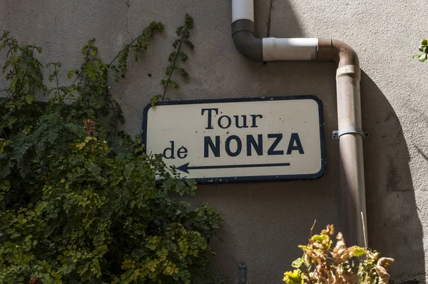 Korsika: das Schild zum Turm von Nonza, einem genuesischen Turm (16. Jh.), der auf den Klippen 100 Meter unterhalb des Meeres errichtet wurde, in einer Gasse von Nonza, einem Dorf an der Westküste von Cap Corse — Stockfoto