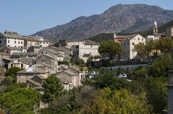 Corsica: veduta dello skyline di Nonza, villaggio sulla costa occidentale di Cap Corse con antiche case arroccate su scogliere a picco a 100 metri dal mare sottostante e la sua torre genovese (XVI secolo ) — Foto Stock