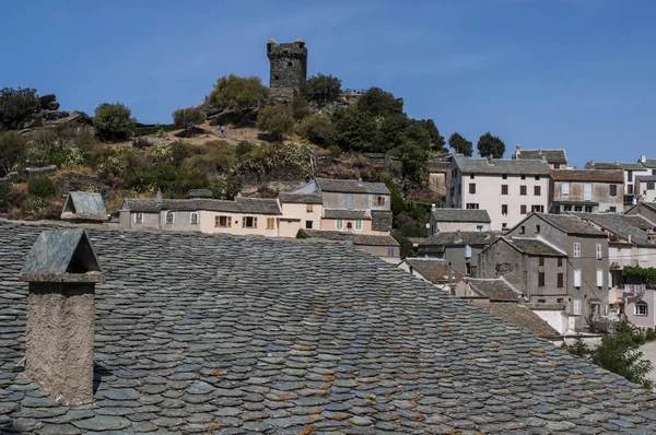 Córcega: vista del horizonte de Nonza, pueblo en la costa occidental de Cap Corse con antiguas casas encaramadas en escarpados acantilados en lo alto de 100 metros hasta el mar y su torre genovesa (siglo XVI) ) — Foto de Stock