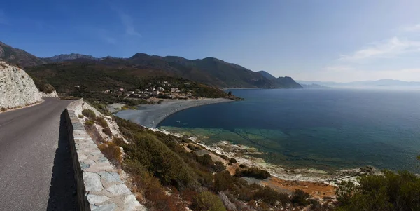 Córcega: el sinuoso camino de la costa occidental del Cap Corse, famoso por su paisaje salvaje, con vista a una de las muchas playas negras a lo largo de la costa —  Fotos de Stock