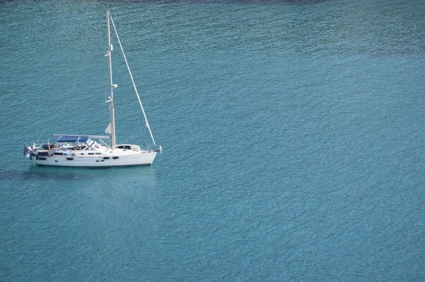 Corsica: a sailboat in the crystal clear water of Anse dAliso or Plage dAlisu, one of the most remote beaches of the western side of Cap Corse, peninsula famous for its wild landscape — Stock Photo, Image