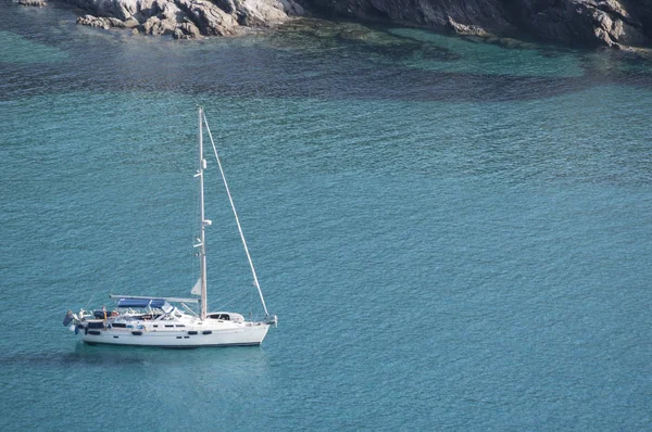 Córcega: un velero en aguas cristalinas de Anse dAliso o Plage dAlisu, una de las playas más remotas del lado occidental de Cap Corse, península famosa por su paisaje salvaje — Foto de Stock