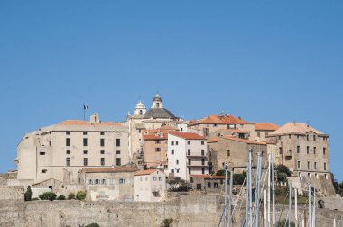 Corsica, 03/09/2017: Calvi, ünlü turistik hedef eski duvarları ve kiliselerin çan kulelerinin adanın kuzeybatı sahilindeki antik kale manzarası görünümünü 