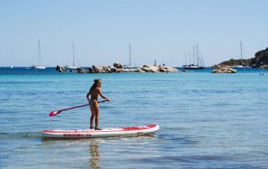 Corsica, 04/09/2017: küçük bir kız bir kürek Santa Giulia, Akdeniz'de üzerinde plaj, uzun beyaz kum plaj, en ünlü Porto Vecchio yakınındaki adanın güney kıyılarının